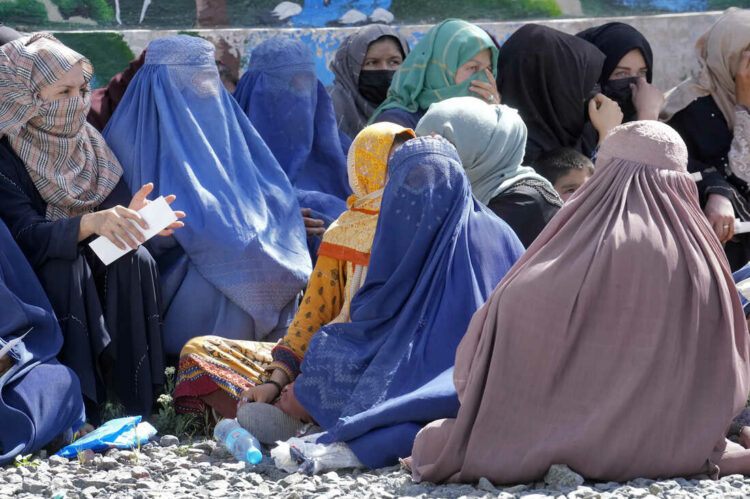 Afghan women wait to receive food rations distributed by a Saudi humanitarian aid group, in Kabul, Afghanistan, Monday, April 25, 2022. Afghanistan’s Taliban rulers on Saturday, May 7,  ordered all Afghan women to wear head-to-toe clothing in public, a sharp hard-line pivot that confirmed the worst fears of rights activists and was bound to further complicate Taliban dealings with an already distrustful international community. (AP Photo/Ebrahim Noroozi)